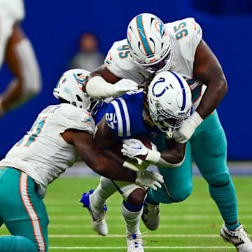 Indianapolis Colts running back Trey Sermon (27) is tackled by Miami Dolphins defensive tackle Benito Jones (95) and  linebacker David Long Jr. (11) during the second half at Lucas Oil Stadium. 