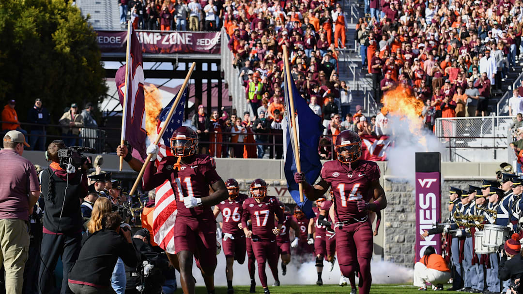 Nov 1, 2025; Blacksburg, Virginia, USA;  Virginia Tech Hokies safety Tyson Flowers (11) and safety Sheldon Robinson (14) run into the stadium before the game against the Louisville Cardinals at Lane Stadium. Mandatory Credit: Brian Bishop-Imagn Images