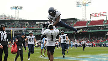 Dec 28, 2024; Boston, MA, USA; Connecticut Huskies wide receiver Skyler Bell (1) celebrates with wide receiver Jasaiah Gathings (4) after scoring a touchdown against the North Carolina Tar Heels during the first half at Fenway Park. Mandatory Credit: Eric Canha-Imagn Images