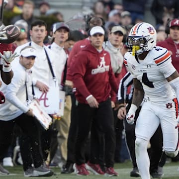Nov 30, 2024; Tuscaloosa, Alabama, USA;  Alabama Crimson Tide wide receiver Germie Bernard (5) makes a catch for a first down against Auburn Tigers cornerback Kayin Lee (4) during the first half at Bryant-Denny Stadium. Mandatory Credit: Gary Cosby Jr.-Imagn Images