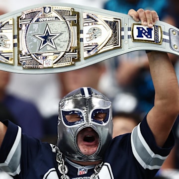 A Dallas Cowboys fan holds up a belt in support of the team before the game against the New York Giants.