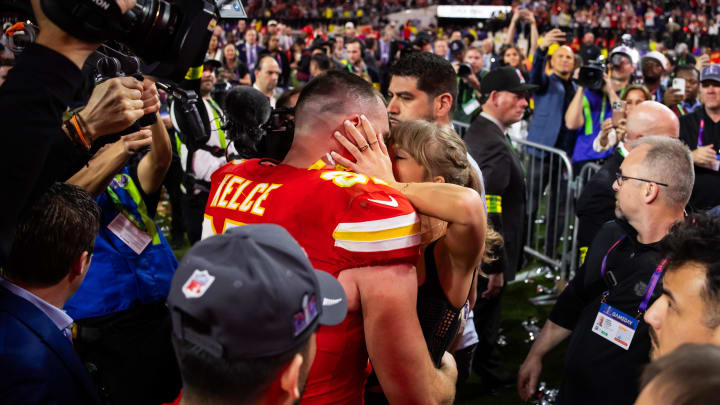 Kansas City Chiefs tight end Travis Kelce (87) kisses girlfriend Taylor Swift as they celebrate after defeating the San Francisco 49ers in Super Bowl LVIII at Allegiant Stadium.