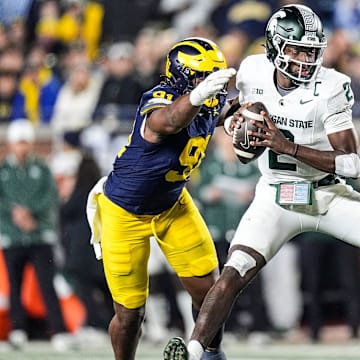 Michigan defensive end Cameron Brandt (91) tackles Michigan State quarterback Aidan Chiles (2) during the second half at Michigan Stadium in Ann Arbor on Saturday, Oct. 26, 2024.