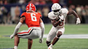 Dec 7, 2024; Atlanta, GA, USA; Texas Longhorns running back Quintrevion Wisner (26) rushes the ball against Georgia Bulldogs defensive back Daylen Everette (6) during the first half in the 2024 SEC Championship game at Mercedes-Benz Stadium. Mandatory Credit: Dale Zanine-Imagn Images