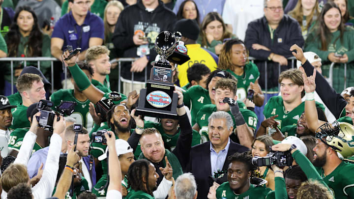 Dec 21, 2023; Boca Raton, FL, USA;  South Florida Bulls head coach Alex Golesh holds up the RoofClaim.com Boca Raton Bowl trophy after beating Syracuse Orange at FAU Stadium. Mandatory Credit: Nathan Ray Seebeck-Imagn Images