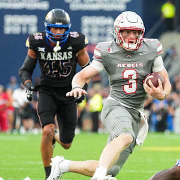 Sep 13, 2024; Kansas City, Kansas, USA; UNLV Rebels quarterback Matthew Sluka (3) runs the ball against Kansas Jayhawks defensive end Dean Miller (45) and cornerback Cobee Bryant (2) during the first half at Children's Mercy Park. Mandatory Credit: Jay Biggerstaff-Imagn Images