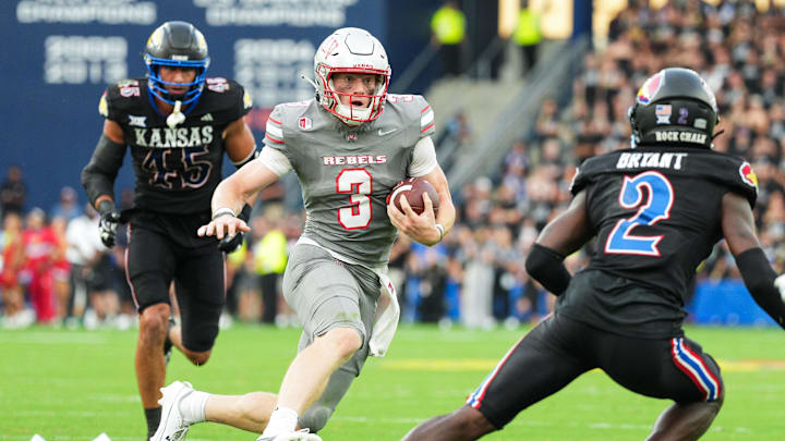 Sep 13, 2024; Kansas City, Kansas, USA; UNLV Rebels quarterback Matthew Sluka (3) runs the ball against Kansas Jayhawks defensive end Dean Miller (45) and cornerback Cobee Bryant (2) during the first half at Children's Mercy Park. Mandatory Credit: Jay Biggerstaff-Imagn Images