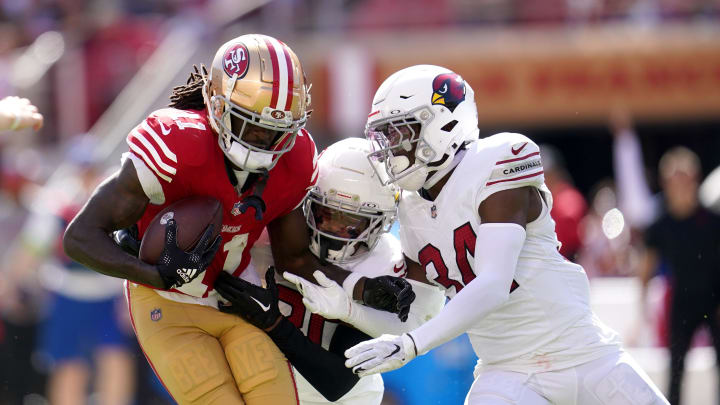 Oct 1, 2023; Santa Clara, California, USA; San Francisco 49ers wide receiver Brandon Aiyuk (11) holds onto the ball after making a catch next to Arizona Cardinals cornerback Marco Wilson (20) and safety Jalen Thompson (34) in the second quarter at Levi's Stadium. Mandatory Credit: Cary Edmondson-USA TODAY Sports
