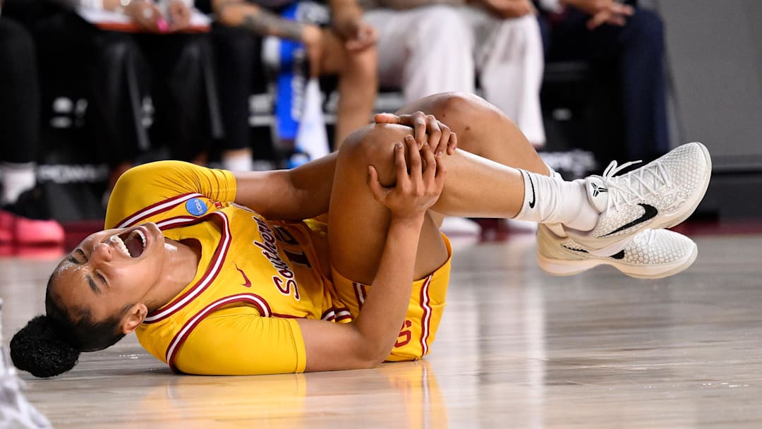 Mar 24, 2025; Los Angeles, California, USA; USC Trojans guard JuJu Watkins (12) grabs her knee after falling g to the floor during the first quarter of an NCAA Tournament second round game against the Mississippi State Bulldogs at Galen Center. Mandatory Credit: Robert Hanashiro-Imagn Images