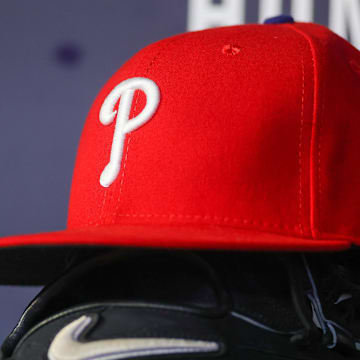 May 26, 2023; Atlanta, Georgia, USA; A detailed view of a Philadelphia Phillies hat and glove on the bench against the Atlanta Braves in the seventh inning at Truist Park. 