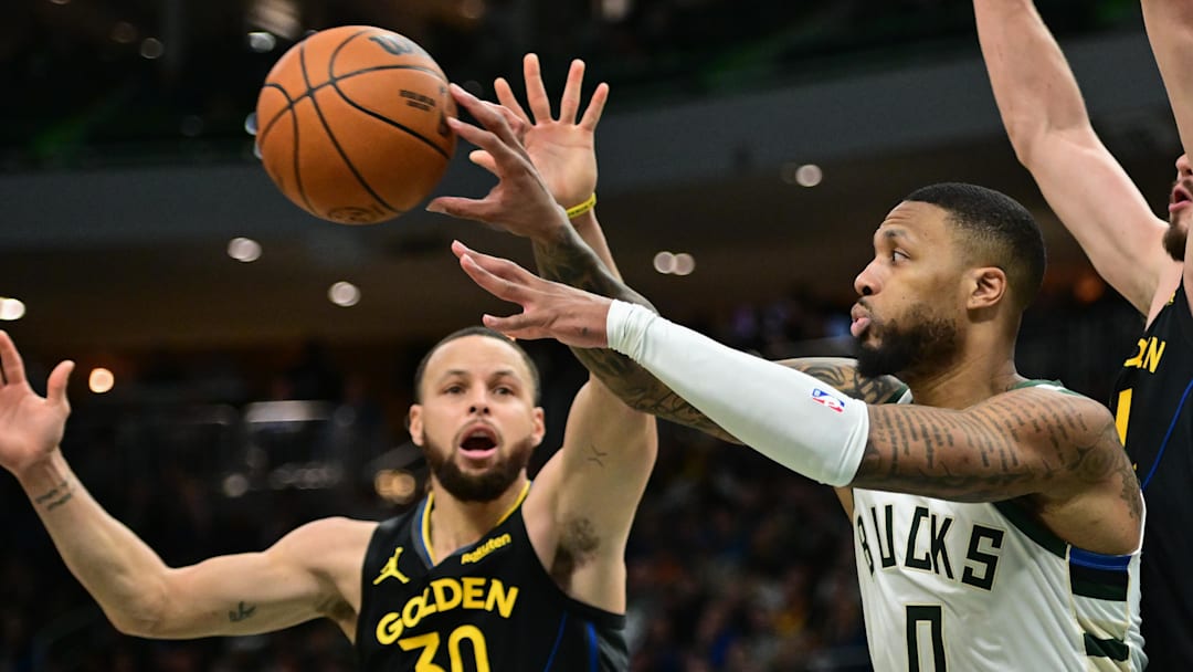 Feb 10, 2025; Milwaukee, Wisconsin, USA; Milwaukee Bucks guard Damian Lillard (0) passes the ball away from Golden State Warriors guard Stephen Curry (30) in the fourth quarter at Fiserv Forum. Mandatory Credit: Benny Sieu-Imagn Images