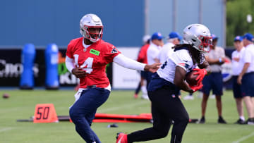 Jun 10, 2024; Foxborough, MA, USA;  New England Patriots quarterback Jacoby Brissett (14) hands the ball to running back Rhamondre Stevenson (38) at minicamp at Gillette Stadium. Mandatory Credit: Eric Canha-USA TODAY Sports