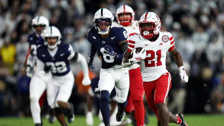 Nov 22, 2025; University Park, Pennsylvania, USA; Nebraska Cornhuskers running back Emmett Johnson (21) runs with the ball during the first quarter against the Penn State Nittany Lions at Beaver Stadium. Mandatory Credit: Matthew O'Haren-Imagn Images
