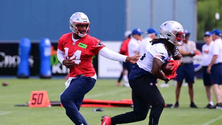 Jun 10, 2024; Foxborough, MA, USA;  New England Patriots quarterback Jacoby Brissett (14) hands the ball to running back Rhamondre Stevenson (38) at minicamp at Gillette Stadium. Mandatory Credit: Eric Canha-USA TODAY Sports