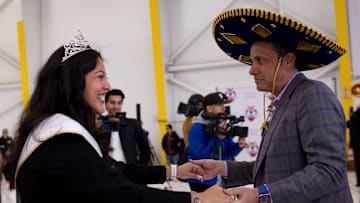 Ashley Rios, the Lady in Waiting for the 2024 Sun Court, dances with Jedd Fisch, Washington's head football coach, as he arrived in El Paso on Thursday, Dec. 26, 2024, for the 2024 Tony the Tiger Sun Bowl.