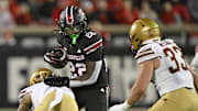 Oct 25, 2025; Louisville, Kentucky, USA;  Louisville Cardinals running back Keyjuan Brown (22) runs the ball against Boston College Eagles defensive back Omar Thornton (0) and linebacker Owen McGowan (33) during the second half at L&N Federal Credit Union Stadium.  Mandatory Credit: Jamie Rhodes-Imagn Images