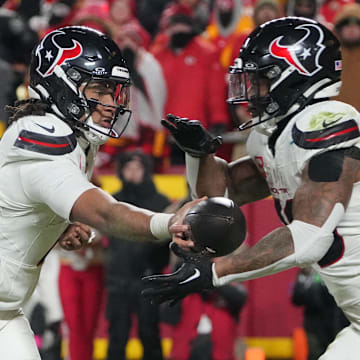 Jan 18, 2025; Kansas City, Missouri, USA; Houston Texans quarterback C.J. Stroud (7)  hands off to running back Joe Mixon (28) against the Kansas City Chiefs during the fourth quarter of a 2025 AFC divisional round game at GEHA Field at Arrowhead Stadium. Mandatory Credit: Denny Medley-Imagn Images