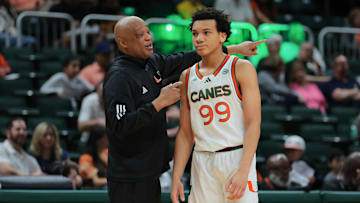Feb 1, 2025; Coral Gables, Florida, USA; Miami Hurricanes interim head coach Bill Courtney talks to guard Divine Ugochukwu (99) during the first half against the Notre Dame Fighting Irish at Watsco Center. Mandatory Credit: Sam Navarro-Imagn Images