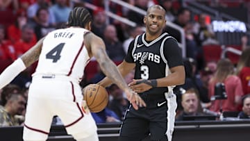 Feb 26, 2025; Houston, Texas, USA; San Antonio Spurs guard Chris Paul (3) dribbles the ball as Houston Rockets guard Jalen Green (4) defends during the first quarter at Toyota Center.