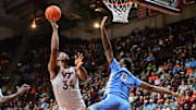 Mar 4, 2025; Blacksburg, Virginia, USA; Virginia Tech Hokies forward Mylyjael Poteat (34) goes up for a shot as North Carolina Tar Heels forward Ty Claude (0) defends during the first half at Cassell Coliseum. Mandatory Credit: Brian Bishop-Imagn Images
