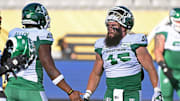 Jun 16, 2024; Hamilton, Ontario, CAN; Saskatchewan Rough Riders wide receiver Justin Bane Jr (15) and Saskatchewan Rough Riders linebacker AJ Allen (32) during warmups against the Hamilton Tiger Cats at Tim Hortons Field. Mandatory Credit: Gerry Angus-Imagn Images