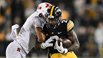 Nov 11, 2023; Iowa City, Iowa, USA; Iowa Hawkeyes running back Kaleb Johnson (2) runs the ball as Rutgers Scarlet Knights defensive back Shaquan Loyal (6) goes for the tackle during the fourth quarter at Kinnick Stadium. Mandatory Credit: Jeffrey Becker-USA TODAY Sports