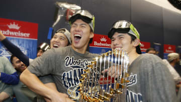 Oct 31, 2025; Toronto, Ontario, CAN; Los Angeles Dodgers two-way player Shohei Ohtani (17) and pitcher Yoshinobu Yamamoto (18) and pitcher Roki Sasaki (11) celebrate with the Commissioner's Trophy in the clubhouse after defeating the Toronto Blue Jays in the 2025 MLB World Series at Rogers Centre. Mandatory Credit: John E. Sokolowski-Imagn Images