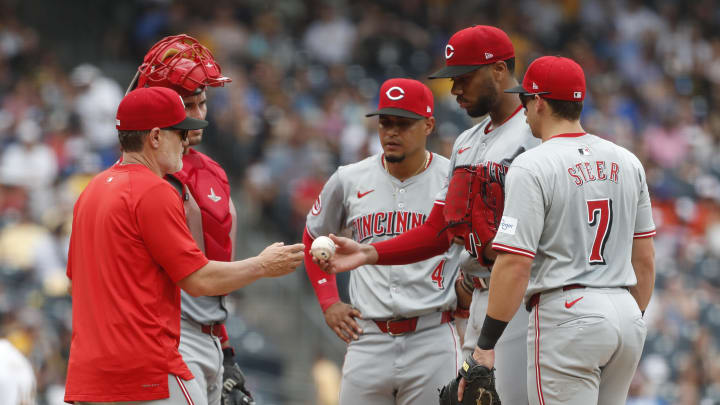 Jun 19, 2024; Pittsburgh, Pennsylvania, USA;  Cincinnati Reds manager David Bell (25) takes the ball from Cincinnati Reds starting pitcher Hunter Greene (21) against the Pittsburgh Pirates during the seventh inning at PNC Park.  The Pirates shutout the Reds 1-0. Mandatory Credit: Charles LeClaire-USA TODAY Sports