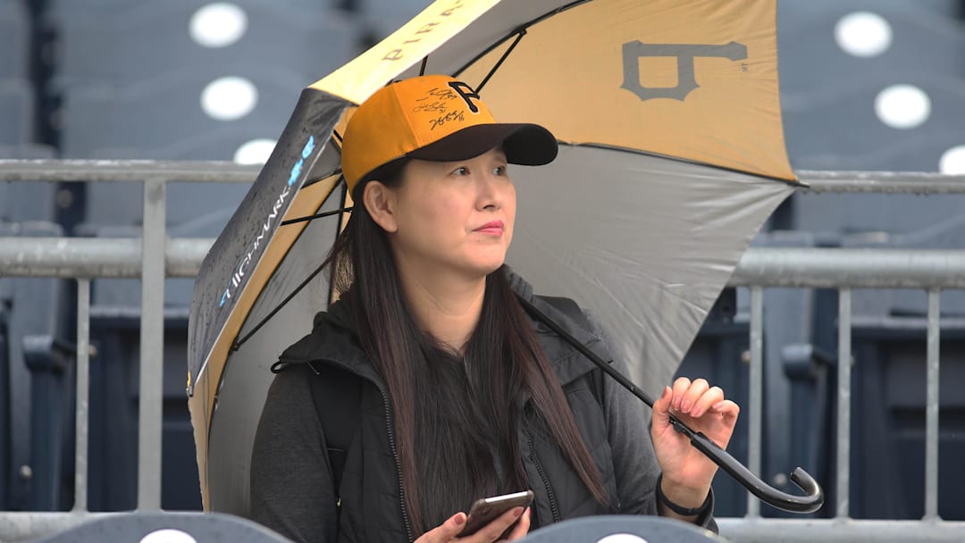 Apr 19, 2019; Pittsburgh, PA, USA;  Pittsburgh Pirates fan Sun Seo looks on as rain falls before the Pirates host the San Francisco Giants at PNC Park. Seo is hoping for the opportunity to watch Pittsburgh Pirates third baseman Jung Ho Kang (not pictured) in action. Mandatory Credit: Charles LeClaire-Imagn Images