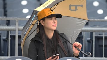 Apr 19, 2019; Pittsburgh, PA, USA;  Pittsburgh Pirates fan Sun Seo looks on as rain falls before the Pirates host the San Francisco Giants at PNC Park. Seo is hoping for the opportunity to watch Pittsburgh Pirates third baseman Jung Ho Kang (not pictured) in action. Mandatory Credit: Charles LeClaire-Imagn Images