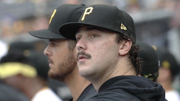 Sep 26, 2024; Pittsburgh, Pennsylvania, USA;  Pittsburgh Pirates pitchers Jared Jones (left) and Paul Skenes (right) look on from the dugout against the Milwaukee Brewers during the third inning at PNC Park. Mandatory Credit: Charles LeClaire-Imagn Images