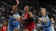 Sep 7, 2025; Las Vegas, Nevada, USA; Las Vegas Aces center A'ja Wilson (22) drives the ball between Chicago Sky center Kamilla Cardoso (10) and guard Rachel Banham (24) during the second half of a WNBA basketball game at T-Mobile Arena. Mandatory Credit: Lucas Peltier-Imagn Images