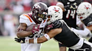 Nov 4, 2023; Louisville, Kentucky, USA;  Virginia Tech Hokies running back Bhayshul Tuten (33) runs the ball against Louisville Cardinals defensive back Cam'Ron Kelly during the first half at L&N Federal Credit Union Stadium. Mandatory Credit: Jamie Rhodes-Imagn Images