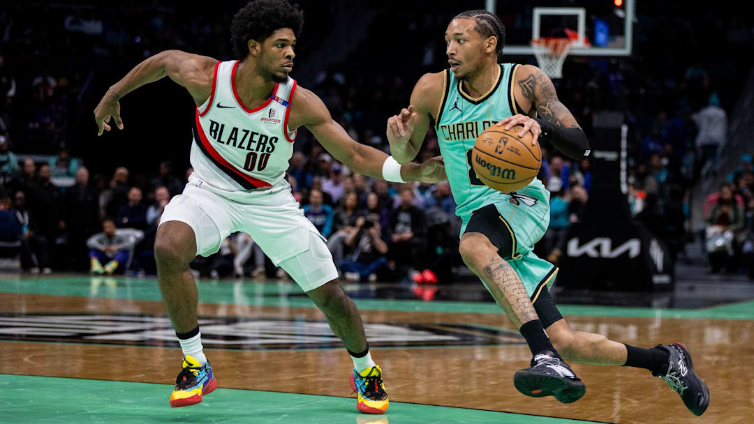 Jan 24, 2025; Charlotte, North Carolina, USA; Charlotte Hornets guard Nick Smith Jr. (8) drives on Portland Trail Blazers guard Scoot Henderson (00) during the second quarter at Spectrum Center. Mandatory Credit: Scott Kinser-Imagn Images