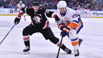 Oct 21, 2023; Buffalo, New York, USA; New York Islanders center Brock Nelson (29) and Buffalo Sabres defenseman Rasmus Dahlin (26) go for the puck in the first period at KeyBank Center. Mandatory Credit: Mark Konezny-Imagn Images