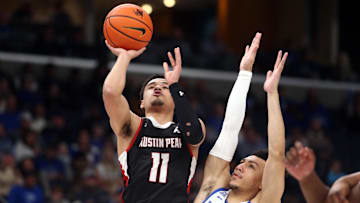 Dec 30, 2023; Memphis, Tennessee, USA; Austin Peay Governors guard Dezi Jones (11) drives to the basket as Memphis Tigers guard Jahvon Quinerly (11) defends during the second half at FedExForum. Mandatory Credit: Petre Thomas-Imagn Images