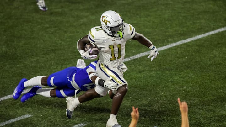 Aug 31, 2024; Atlanta, Georgia, USA; Georgia Tech Yellow Jackets running back Jamal Haynes (11) runs the ball past Georgia State Panthers safety Isaiah Holland (13) in the second quarter at Bobby Dodd Stadium at Hyundai Field. Mandatory Credit: Brett Davis-Imagn Images
