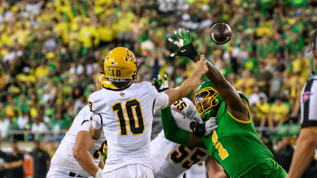  Idaho Vandals quarterback Jack Wagner (10) throws a pass under pressure from Oregon Ducks defensive end Jordan Burch (1)