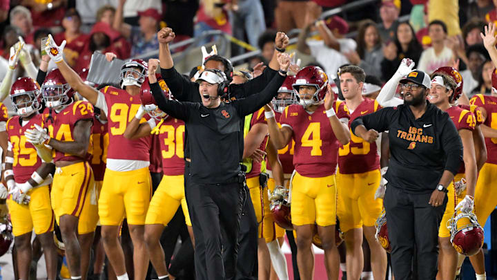 Oct 11, 2025; Los Angeles, California, USA;  USC Trojans head coach Lincoln Riley (wearing white visor) celebrates along with defensive end coach Shaun Nua after kicker Ryon Sayeri (48) hit a 54-yard field goal in the second half against the Michigan Wolverines at United Airlines Field at the Los Angeles Memorial Coliseum. Mandatory Credit: Jayne Kamin-Oncea-Imagn Images