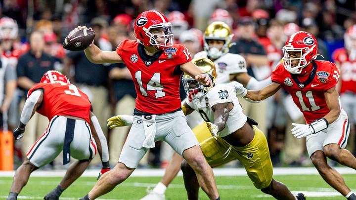 Jan 2, 2025; New Orleans, LA, USA;  Georgia Bulldogs quarterback Gunner Stockton (14) passes against Notre Dame Fighting Irish defensive lineman RJ Oben (9) during the second half at Caesars Superdome. Mandatory Credit: Stephen Lew-Imagn Images