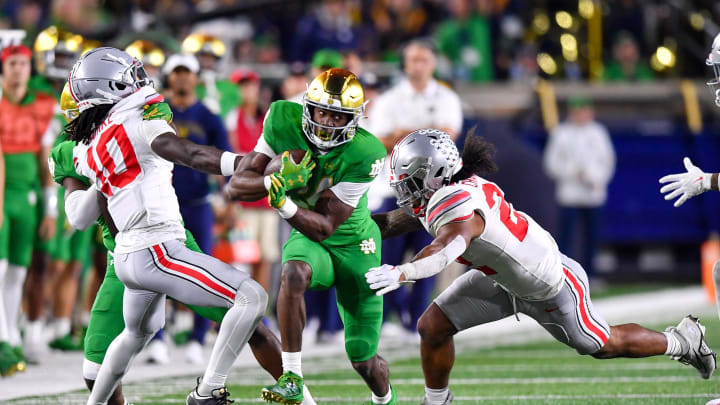 Sep 23, 2023; South Bend, Indiana, USA; Notre Dame Fighting Irish running back Jadarian Price (24) runs the ball as Ohio State Buckeyes cornerback Denzel Burke (10) and linebacker Steele Chambers (22) attempt to tackle in the third quarter at Notre Dame Stadium. 