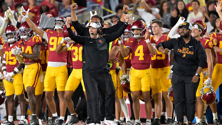 Oct 11, 2025; Los Angeles, California, USA;  USC Trojans head coach Lincoln Riley (wearing white visor) celebrates along with defensive end coach Shaun Nua after kicker Ryon Sayeri (48) hit a 54-yard field goal in the second half against the Michigan Wolverines at United Airlines Field at the Los Angeles Memorial Coliseum. Mandatory Credit: Jayne Kamin-Oncea-Imagn Images