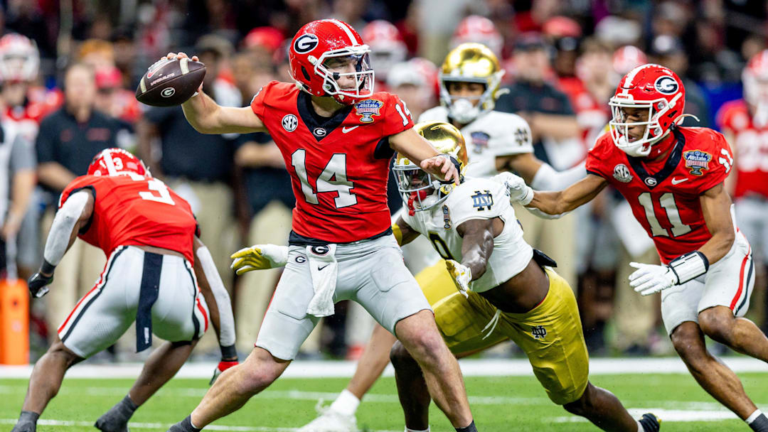 Jan 2, 2025; New Orleans, LA, USA;  Georgia Bulldogs quarterback Gunner Stockton (14) passes against Notre Dame Fighting Irish defensive lineman RJ Oben (9) during the second half at Caesars Superdome. Mandatory Credit: Stephen Lew-Imagn Images