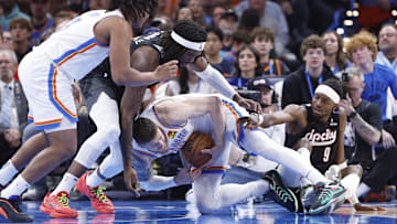 Nov 20, 2024; Oklahoma City, Oklahoma, USA; Oklahoma City Thunder center Isaiah Hartenstein (55) fights for a loose ball with Portland Trail Blazers center Robert Williams III (35) and forward Jerami Grant (9) during the second half at Paycom Center. Mandatory Credit: Alonzo Adams-Imagn Images