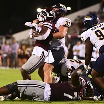 Mississippi State Bulldogs running back Johnnie Daniels (20) is tackled by Toledo Rockets linebacker Daniel Bolden (31) during the fourth quarter at Davis Wade Stadium at Scott Field.