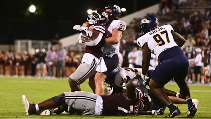 Mississippi State Bulldogs running back Johnnie Daniels (20) is tackled by Toledo Rockets linebacker Daniel Bolden (31) during the fourth quarter at Davis Wade Stadium at Scott Field.