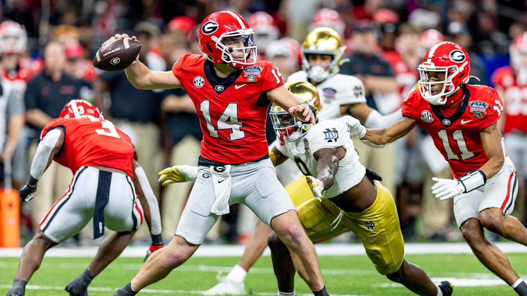 Jan 2, 2025; New Orleans, LA, USA;  Georgia Bulldogs quarterback Gunner Stockton (14) passes against Notre Dame Fighting Irish defensive lineman RJ Oben (9) during the second half at Caesars Superdome. Mandatory Credit: Stephen Lew-Imagn Images