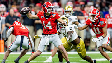 Jan 2, 2025; New Orleans, LA, USA;  Georgia Bulldogs quarterback Gunner Stockton (14) passes against Notre Dame Fighting Irish defensive lineman RJ Oben (9) during the second half at Caesars Superdome. Mandatory Credit: Stephen Lew-Imagn Images