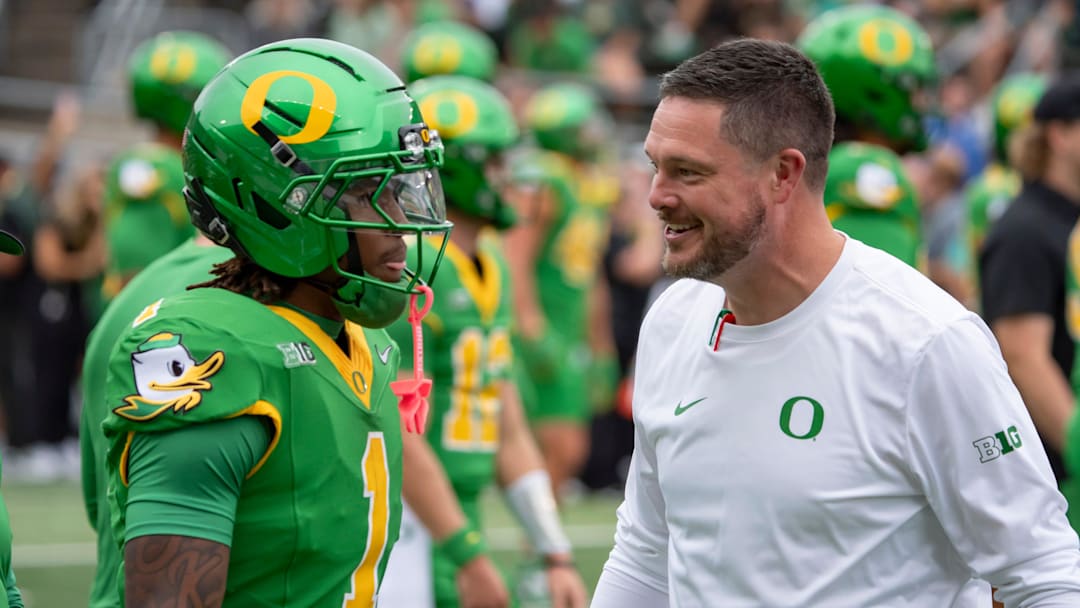 Oregon head coach Dan Lanning, right, talks with Oregon wide receiver Dakorien Moore during warmups as the Oregon Ducks host the Oklahoma State Cowboys on Sept. 6, 2025, at Autzen Stadium in Eugene, Oregon.