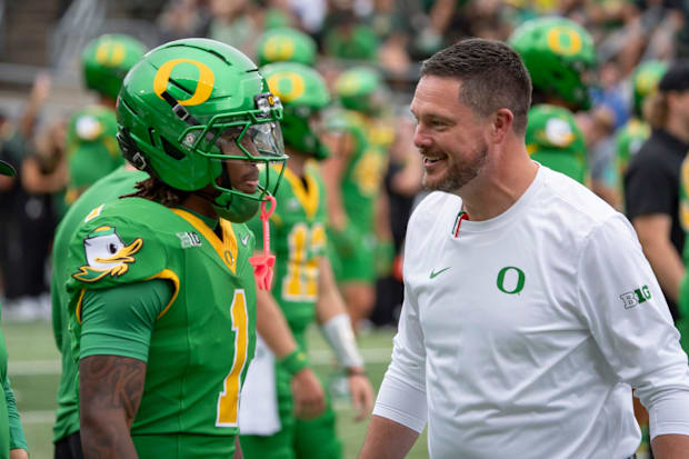 Oregon head coach Dan Lanning, right, talks with Oregon wide receiver Dakorien Moore during warmups as the Oregon Ducks host 